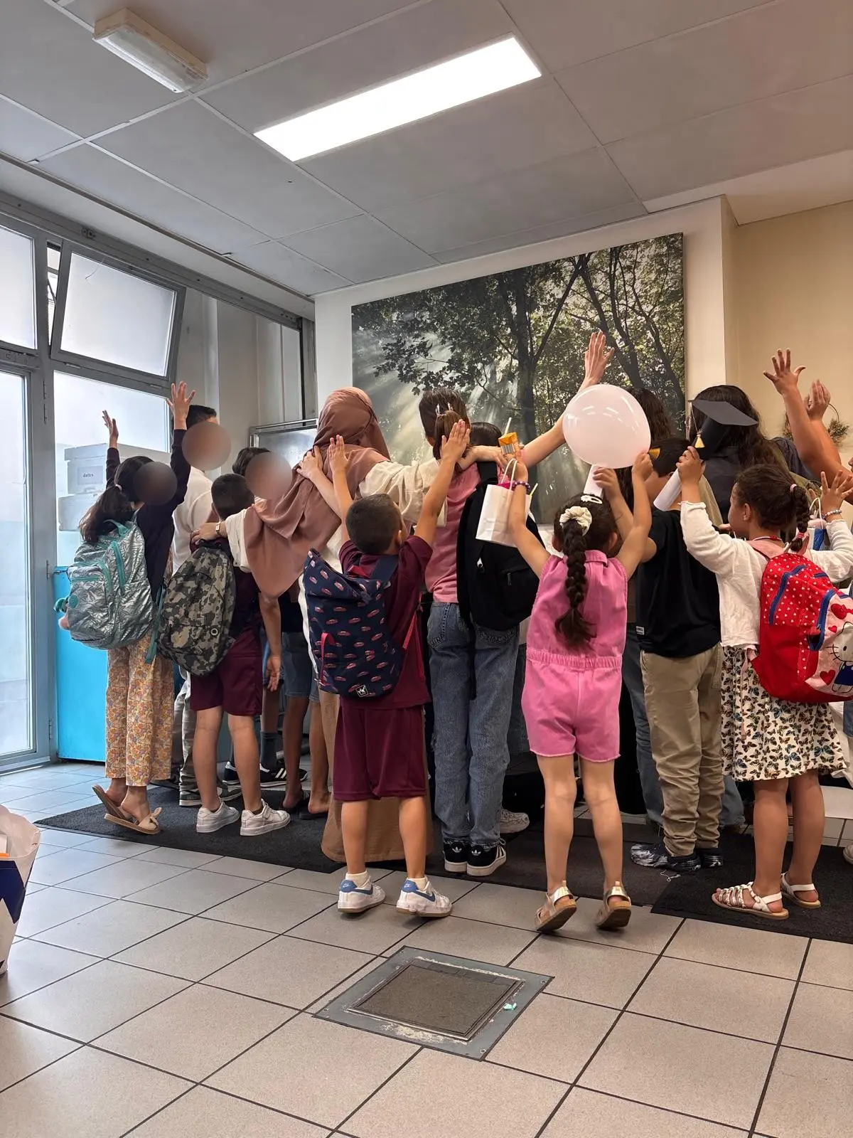 Un groupe d'enfants et d'adolescents, bras levés, lors d'une activité de l'institut
